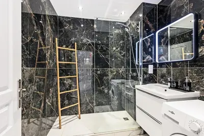 a bathroom with a black marble wall at Mimosas Lovers in Cannes