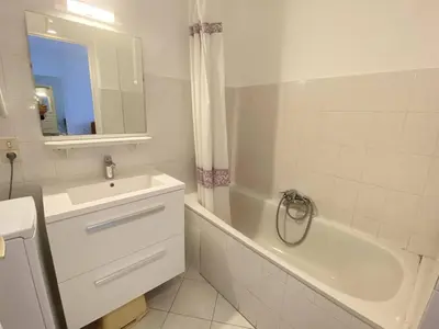 a bathroom with a sink and a tub and a sink and a mirror at Cannes proche Croisette - Studio balcon vue sur jardin in Cannes