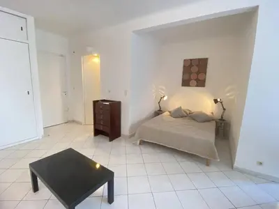 a bedroom with a bed and a coffee table at Cannes proche Croisette - Studio balcon vue sur jardin in Cannes