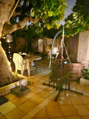a patio with a swing and a table and chairs at La Sérénade in Vallauris