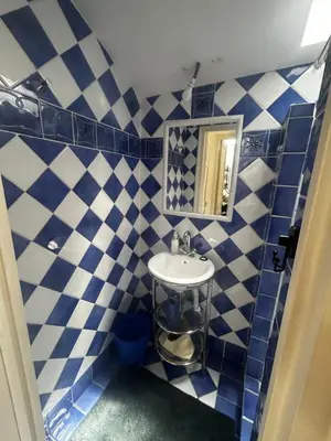 a blue and white tiled bathroom with a sink at La Sérénade in Vallauris