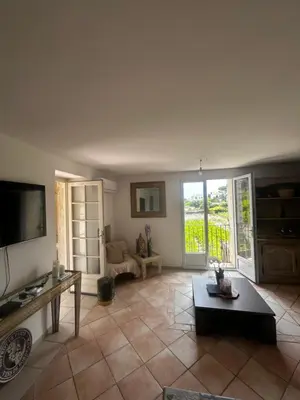 a living room with a couch and a tv at La Sérénade in Vallauris