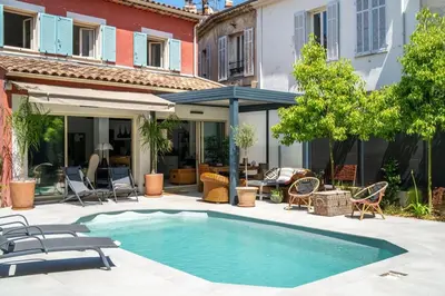 a swimming pool in a yard with chairs and a house at Magnifique villa avec piscine in Le Cannet