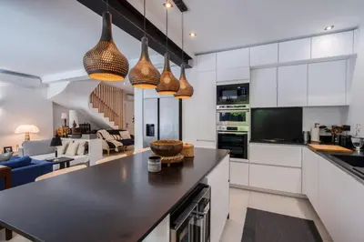 a kitchen with white cabinets and a black counter top at Magnifique villa avec piscine in Le Cannet