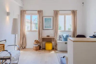 a white room with a bed and a table and windows at Magnifique villa avec piscine in Le Cannet