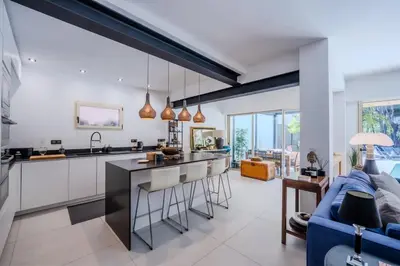 a kitchen and living room with a blue couch at Magnifique villa avec piscine in Le Cannet