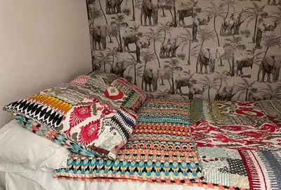 a bed with a quilt and pillows on it at Panter Properties-24 in Cannes