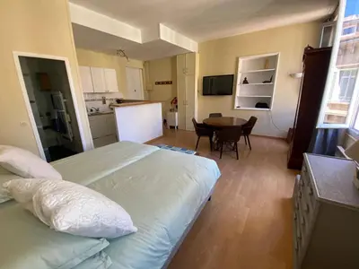a bedroom with a bed and a kitchen with a table at Panter Properies Studio in Cannes