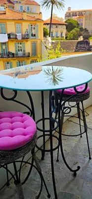 a table and two chairs with pink cushions on a balcony at Cannes South of France Apartment near beach, Palais des Festivals and Croisette in Cannes