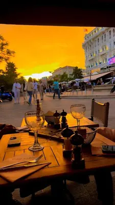 a wooden table with wine glasses on a city street at Cannes South of France Apartment near beach, Palais des Festivals and Croisette in Cannes