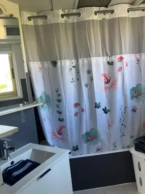 a bathroom with a shower curtain with flowers on it at Cannes South of France Apartment near beach, Palais des Festivals and Croisette in Cannes