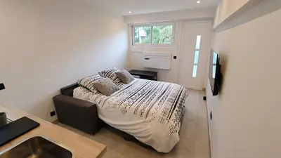 a small bedroom with a bed and a window at Studio moderne in Cannes