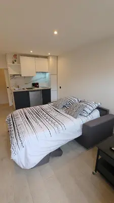 a large bed in a room with a kitchen at Studio moderne in Cannes