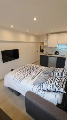 a large bed in a room with a kitchen at Studio moderne in Cannes
