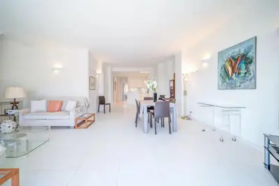 a white living room with a table and a couch at REF 774 - Cannes Old Port - Sea view partment for rent in Cannes