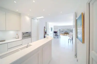a kitchen with white cabinets and a dining room at REF 774 - Cannes Old Port - Sea view partment for rent in Cannes