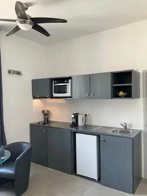 a kitchen with gray cabinets and a ceiling fan at Studio à Cannes quartier du Suquet in Cannes