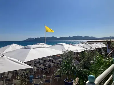 a row of tables and chairs with umbrellas on the beach at Studio à Cannes quartier du Suquet in Cannes