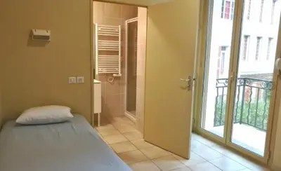 a bedroom with a bed and a walk in shower at Campus Santa Maria in Cannes