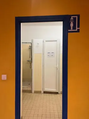 a bathroom with a door leading to a shower at Campus Santa Maria in Cannes
