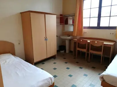 a bedroom with a bed and a desk and a sink at Campus Santa Maria in Cannes