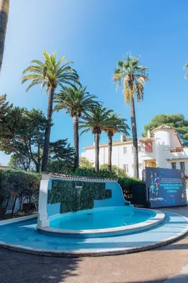 a pool in a park with palm trees at Campus Santa Maria in Cannes