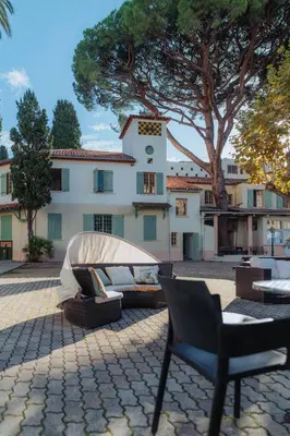 a bed in front of a building with a tree at Campus Santa Maria in Cannes