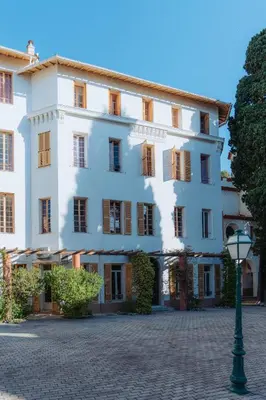 a large white building with a street light in front at Campus Santa Maria in Cannes