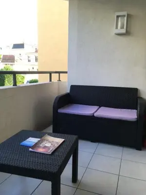 a couch sitting on a balcony with a table at Le Carre Montfleury Cannes in Cannes