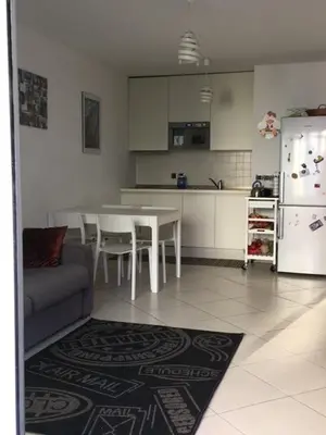 a kitchen with a table and chairs and a refrigerator at Le Carre Montfleury Cannes in Cannes