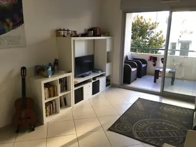 a living room with a television and a guitar at Le Carre Montfleury Cannes in Cannes