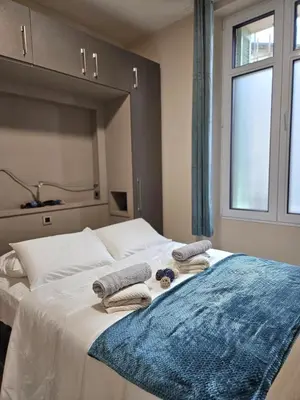 a bedroom with a bed with towels and a window at Central Cannes Cozy T4 Walk to Beach & Congress in Cannes