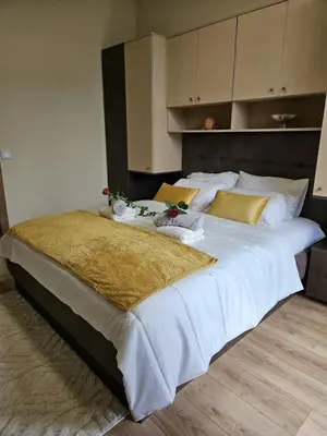 a large bed with white sheets and yellow pillows at Central Cannes Cozy T4 Walk to Beach & Congress in Cannes