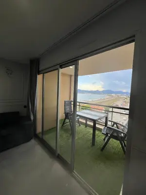 a room with a balcony with a table and chairs at Apartment Cannes sea view! in Cannes