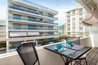 a table and chairs on a balcony with a building at Charming & Elegant La Croisette apartment in Cannes in Cannes