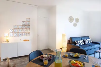 a living room with a table and a blue couch at C10 - 3P 10 min Palais Festivals & Sea - AC & Parking in Cannes