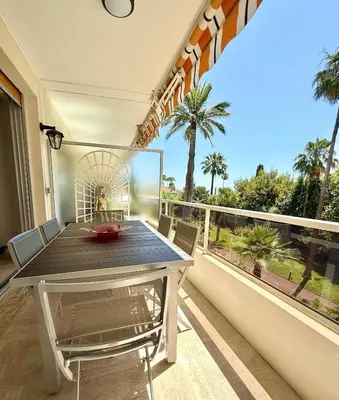 a dining room with a table and a large window at Marilyn Beach - Vue mer, terrasse, garage privé in Cannes