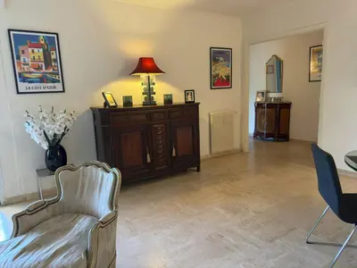 a living room with a chair and a table at Marilyn Beach - Vue mer, terrasse, garage privé in Cannes