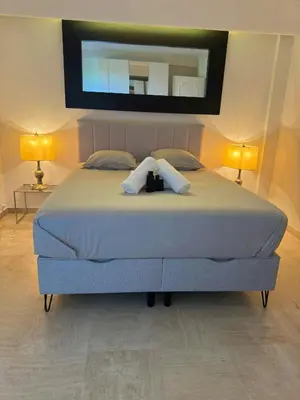 a bedroom with a large bed with a mirror on the wall at Marilyn Beach - Vue mer, terrasse, garage privé in Cannes