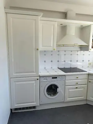 a kitchen with white cabinets and a washing machine at Marilyn Beach - Vue mer, terrasse, garage privé in Cannes
