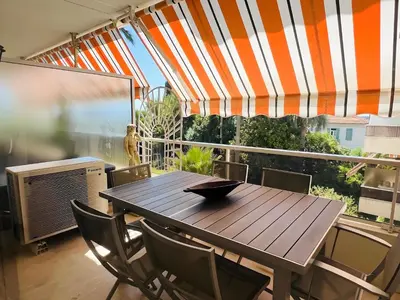 a wooden table and chairs on a balcony at Marilyn Beach - Vue mer, terrasse, garage privé in Cannes