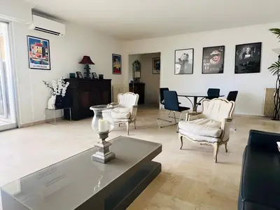 a living room with a table and chairs at Marilyn Beach - Vue mer, terrasse, garage privé in Cannes