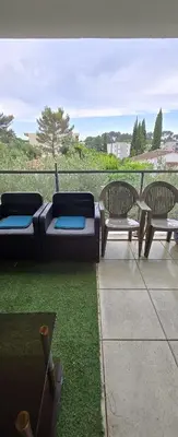 three chairs and a couch on a patio with grass at T2 42 m2 private residence parking in Le Cannet