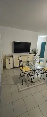 a living room with a table and a television at T2 42 m2 private residence parking in Le Cannet