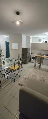 a living room with a table and chairs in it at T2 42 m2 private residence parking in Le Cannet