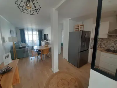 a kitchen and living room with a refrigerator and a table at Appartement rêves d'or in Cannes