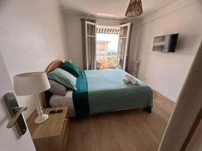 a small bedroom with a bed and a television at Appartement rêves d'or in Cannes