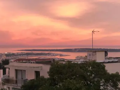 a view of a city with a sunset at Appartement rêves d'or in Cannes