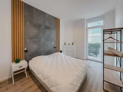 a bedroom with a large bed and a large window at Cozy Home Cannes in Cannes