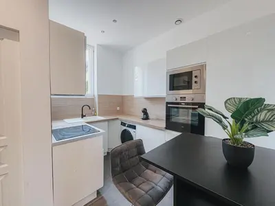 a kitchen with a table and a chair and a microwave at Cozy Home Cannes in Cannes